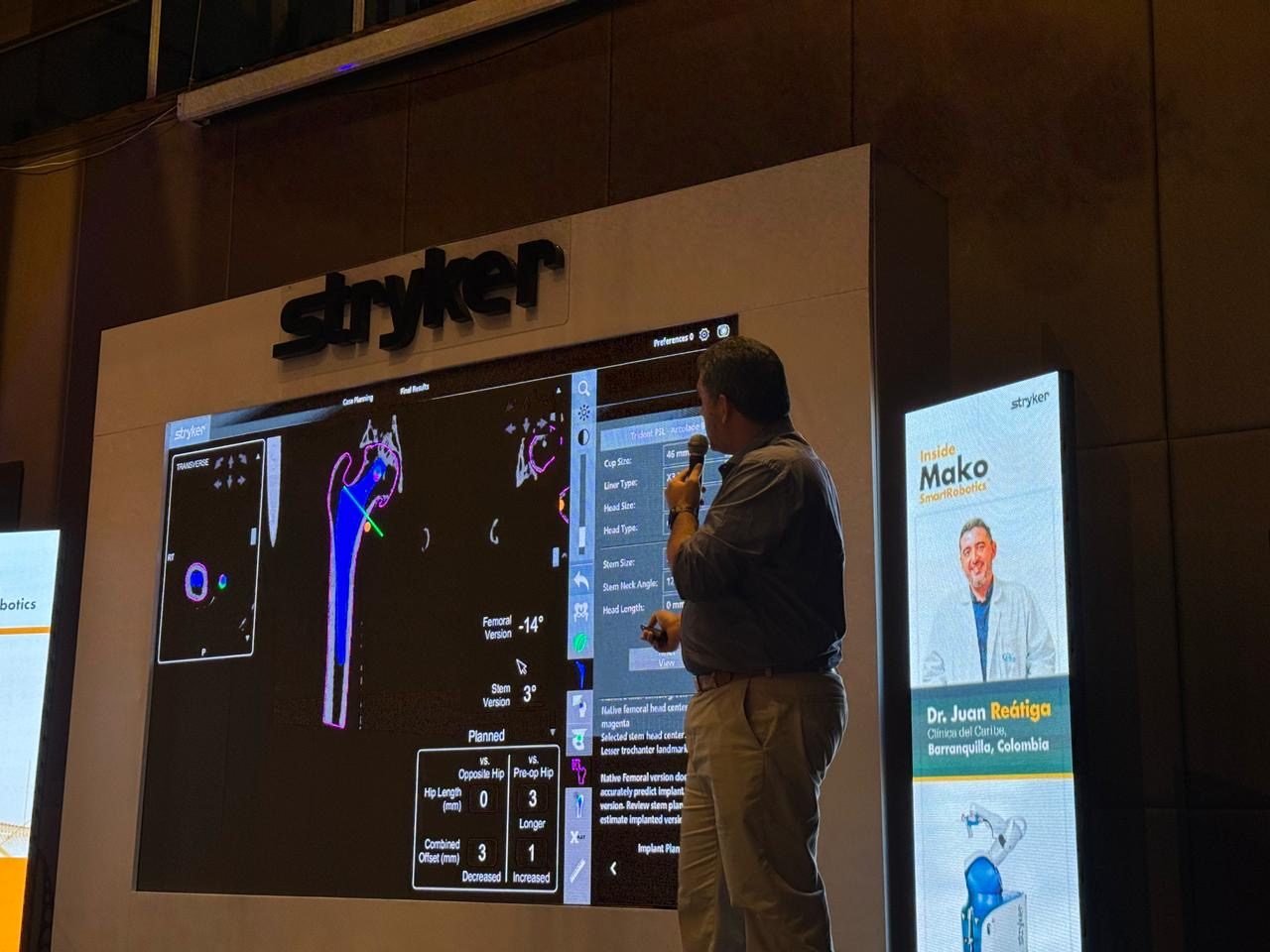El Dr. Reátiga exponiendo un caso de cadera en Inside Mako, con su nombre en la pantalla del evento de Stryker